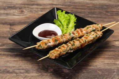 İnce kıymalı domuz şişi kebap ve bbq sosu.