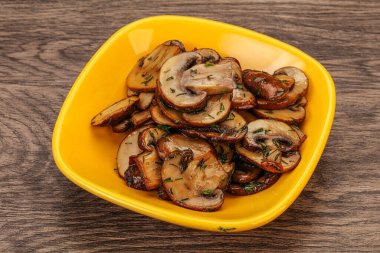 Kavrulmuş şampiyon, kasede otlar ve baharatlar var.