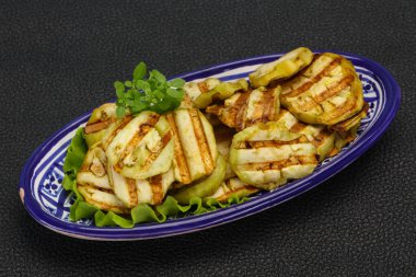 Izgara patlıcan dilimleri fesleğen ve salata yaprakları servis edilir.