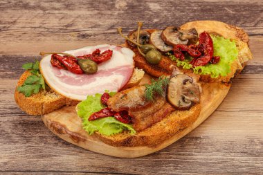 İtalyan aperatifi - et ve sebzelerle karışık bruschetta.