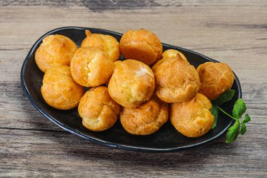 Tatlı, lezzetli profiteroller kasede nane şekeri servis ediliyor.