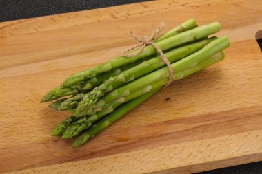 Ahşap tahtanın üzerine çiğ kuşkonmaz yığını