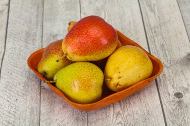 Tahta sepetteki olgun armut yığını.