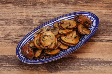 Kavrulmuş şampiyon, kasede otlar ve baharatlar var.