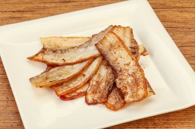 Kızarmış domuz pastırması tabakta.