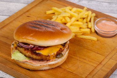 Tavuk, peynir, biber, salatalık ve kırmızı soğanlı hamburger.