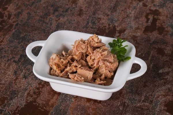 Canned tuna fish in the bowl served basil leaves