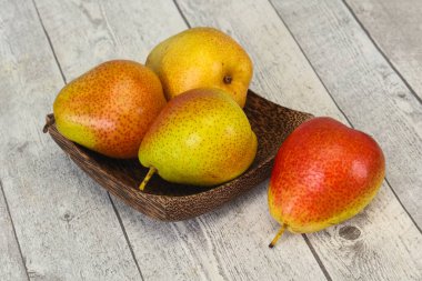 Tahta sepetteki olgun armut yığını.