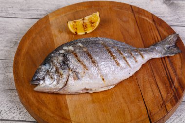 Tahtanın üzerinde limonlu ızgara dorada.