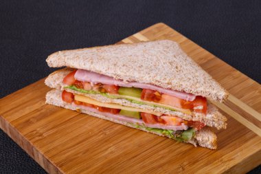 Jambon, peynir, salata yaprakları, domates ve salatalık turşusu ile kulüp sandviç