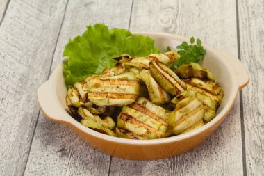 Izgara patlıcan dilimleri fesleğen ve salata yaprakları servis edilir.