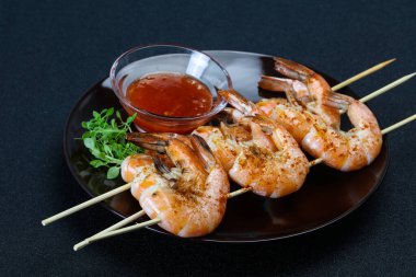 Baharatlı soslu ızgara karides şişi.