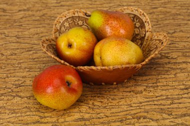 Tahta sepetteki olgun armut yığını.