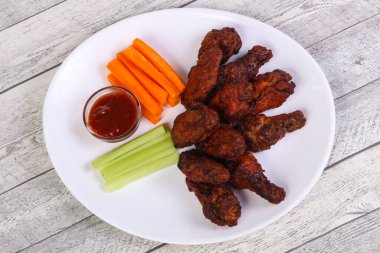 Tavuk kanatları kereviz ve havuç dilimli.