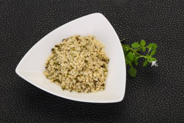 Ahşap arka planda kabuktaki kenevir tohumları.