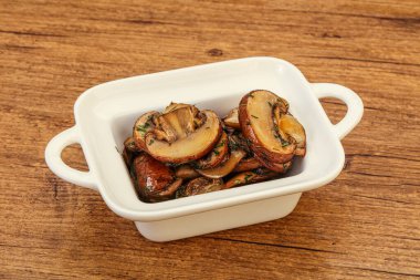 Kavrulmuş şampiyon, kasede otlar ve baharatlar var.