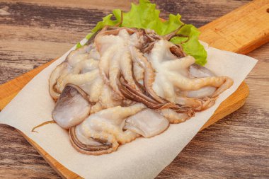 Çiğ deniz ürünleri - ahtapot tahtada pişirmek için.