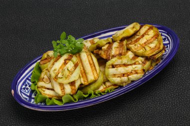 Izgara patlıcan dilimleri fesleğen ve salata yaprakları servis edilir.