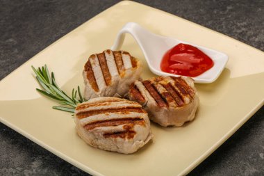 Domates soslu ızgara domuz madalyonu. Biberiye servis ediliyor.