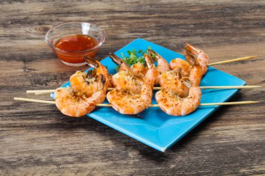 Baharatlı soslu ızgara karides şişi.