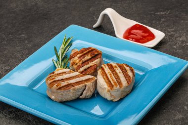 Domates soslu ızgara domuz madalyonu. Biberiye servis ediliyor.