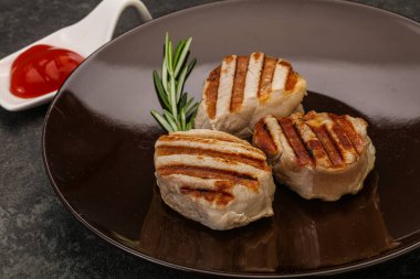 Domates soslu ızgara domuz madalyonu. Biberiye servis ediliyor.