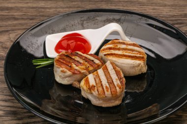 Domates soslu ızgara domuz madalyonu. Biberiye servis ediliyor.