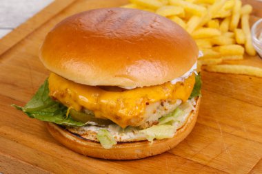 Balık, peynir ve salata soslu ev yapımı burger patates ve beyaz sos.