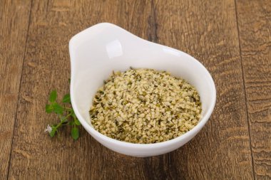 Ahşap arka planda kabuktaki kenevir tohumları.