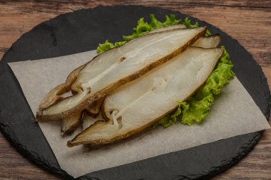 Lezzetli füme halibut balığı aperatifi keser.