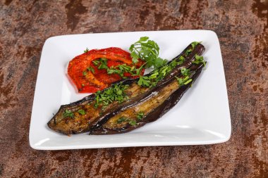 Dolmalık biberli ızgara patlıcan yeşil otlar ve baharatlar servis edilir.