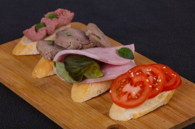 Domatesli, jambonlu ve dilli, salata yapraklı ve kaparili