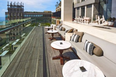 Boş teras. Lüks otel restoranı manzaralı. Masaları ve yastıklı kanepeleri var. Güneşin doğuşunu görmek için rahat bir yer.