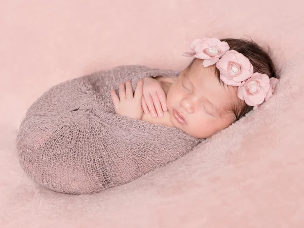 Recién nacida durmiendo sobre un fondo rosa — Foto de Stock