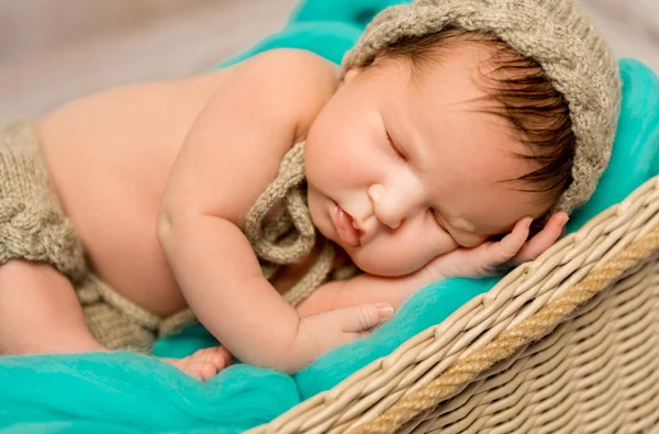 Asleep newborn baby in wicker cot — Stock Photo, Image