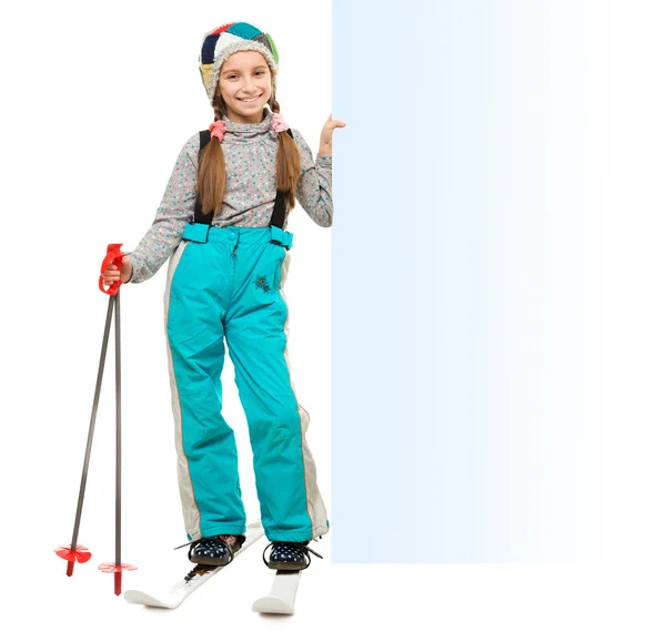 Mädchen mit Skiern zeigt auf einen leeren Rohling — Stockfoto