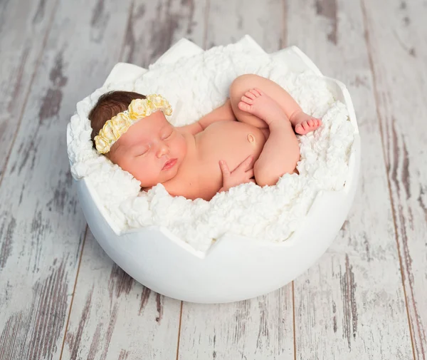 Slapende pasgeboren meisje in eierschaal mand — Stockfoto