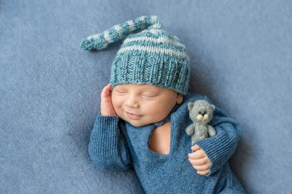 Smilimg recém-nascido adormecido em terno azul — Fotografia de Stock