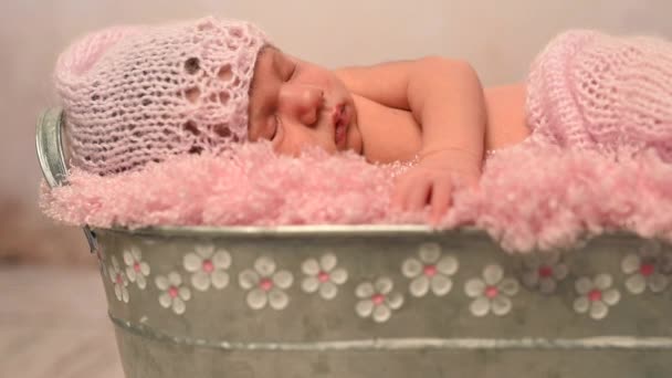 Heerlijk slapen pasgeborene in roze hoed en deken in bedje — Stockvideo