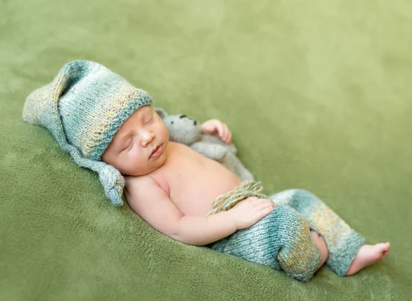 Adorável recém-nascido em chapéu e calcinha dorme enrolado — Fotografia de Stock