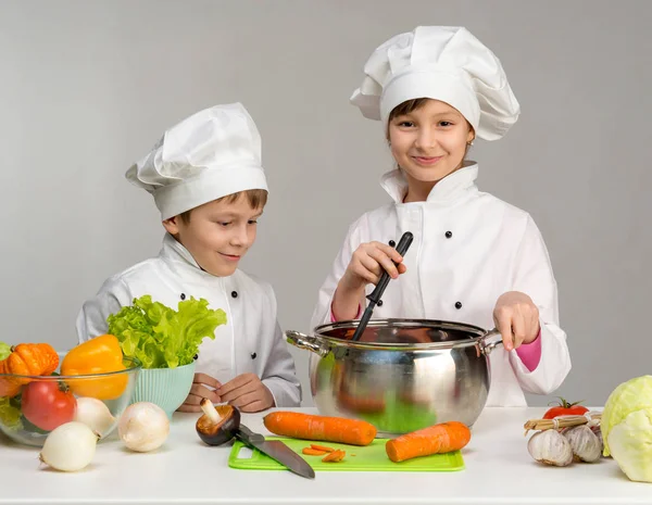 Dois pequenos chefs cozinhando — Fotografia de Stock