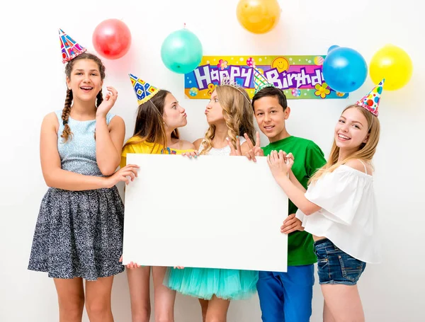 Teenagers at a birthday party holding banner — Stock Photo, Image