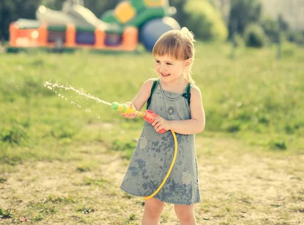 Kleines Mädchen spielt Wasserpistole — Stockfoto