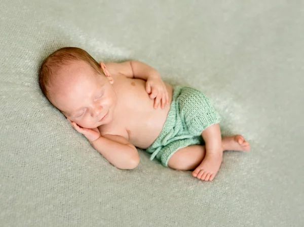 Sover barnet med handen under huvudet — Stockfoto