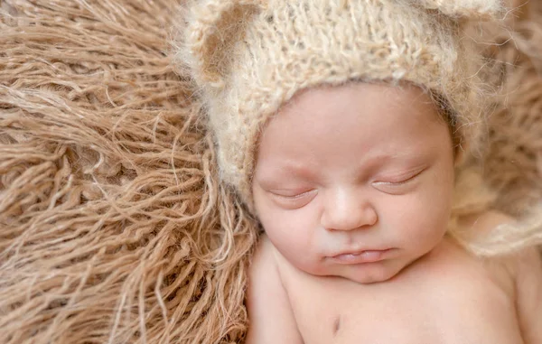 Adormecido sorrindo bebê recém-nascido em chapéu — Fotografia de Stock