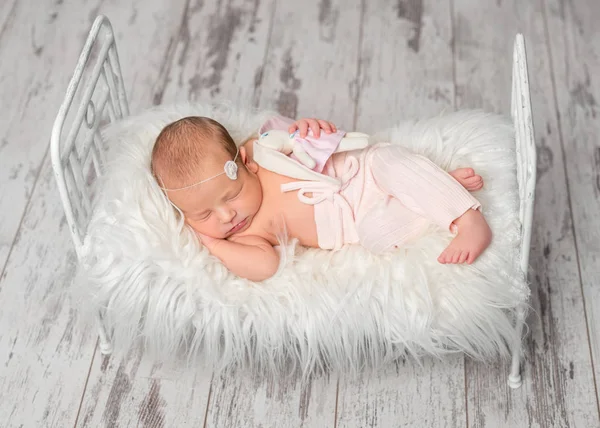 Newborn sleeping baby holding toy — Stock Photo, Image