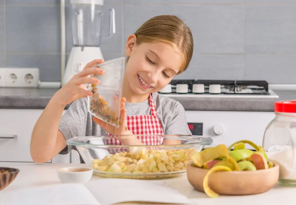 Petite fille avec des pommes coupées dans un bol — Photo