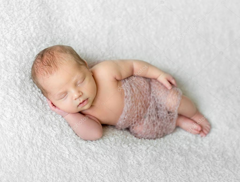 sleeping baby covered with knitted shawl