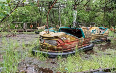 rusty cars in abandoned playground of Pripyat park clipart