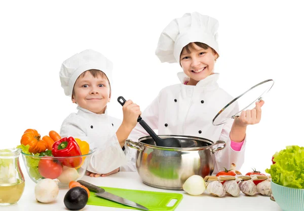 Little chefs by table with vegetables — Stock Photo, Image
